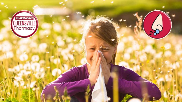 Young girl blowing nose into tissue, standing in a field.
