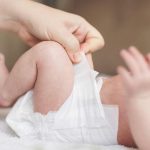 Image of infant laying on back, wearing a diaper.