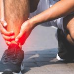 Man holding right ankle, obvious discomfort in calf muscle.