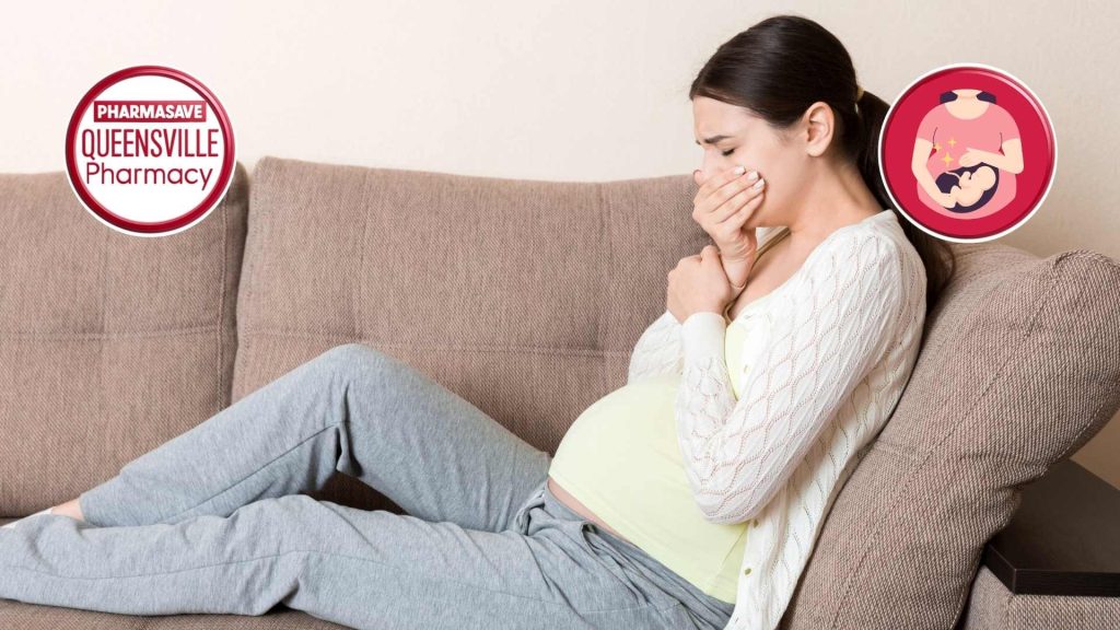 Pregnant woman on couch holding mouth, trying not to vomit.